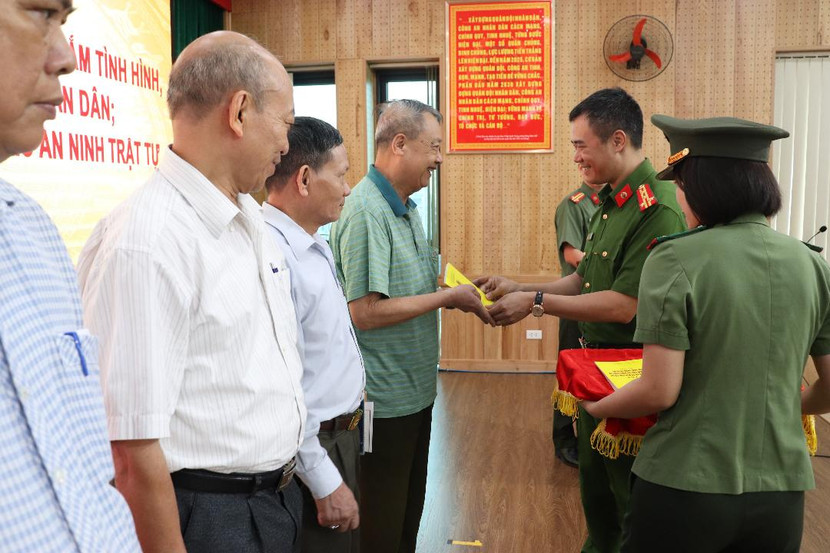 Chỉ huy CAQ Hà Đông trao "Sổ tay Dành cho cán bộ tổ hoà giải cơ sở tham gia đảm bảo ANTT trên địa bàn quận" tặng đại diện các Tổ hòa giải