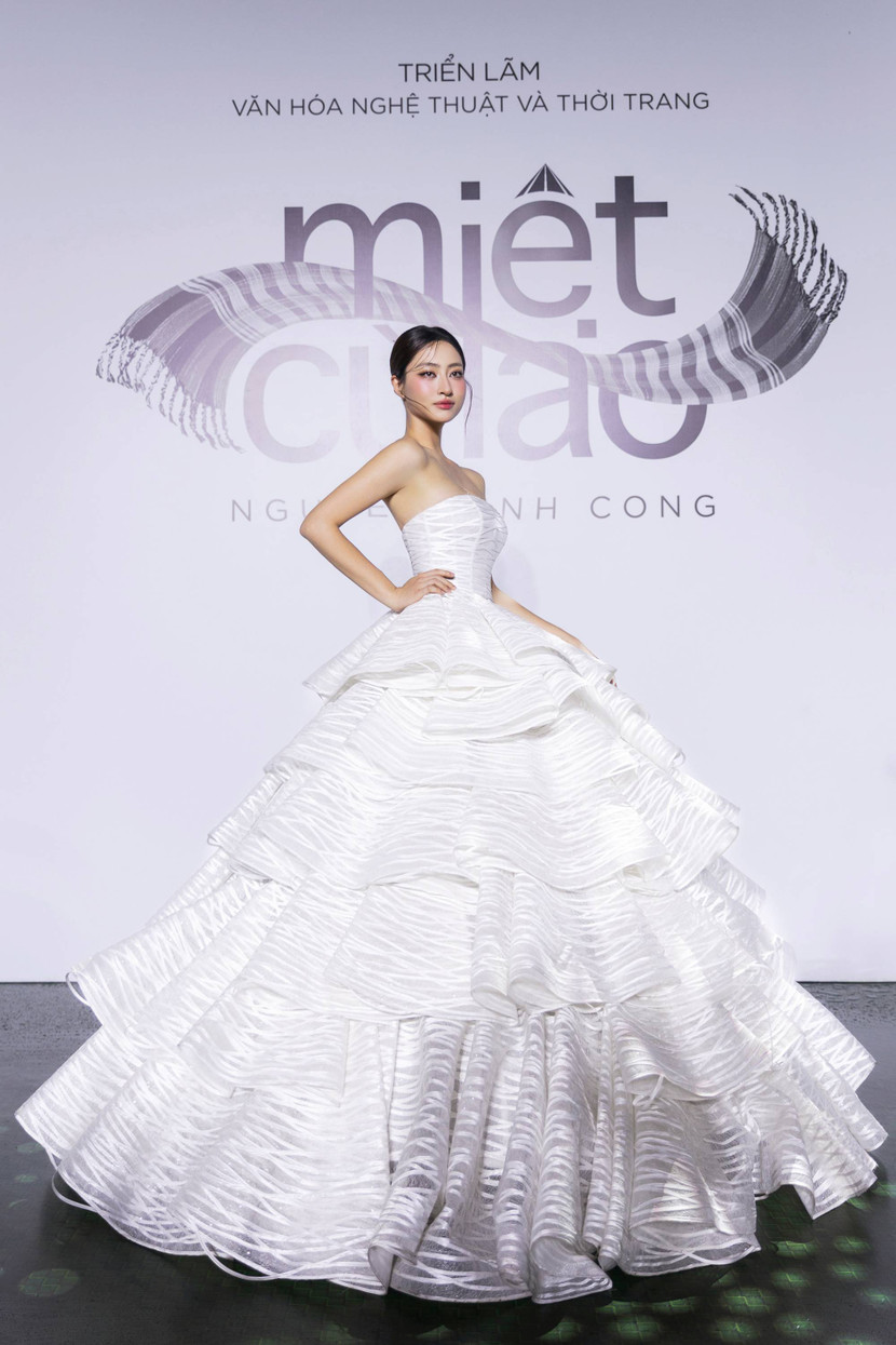 Hoa hậu Lương Thùy Linh khép lại sàn diễn với “Bánh tráng rế”. Lớp ren tone trắng được thiết kế từng tầng cùng độ cong mềm đặc trưng tạo nên vẻ ngoài bồng bềnh, thướt tha và sang trọng của thiết kế
