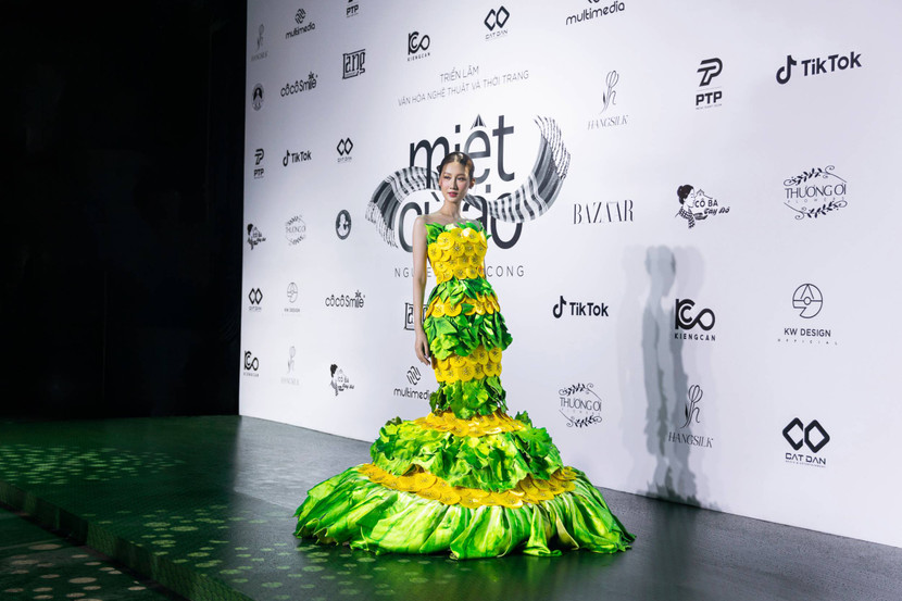 Hoa hậu Võ Lê Quế Anh khoe thân hình mảnh khảnh với thiết kế “Bánh khọt” mang form dáng váy ôm và phần tà váy đuôi cá. Bộ trang phục “Bánh khọt” đính kết các phần bánh khọt làm điểm nhấn với tone màu chủ đạo xanh lá của rau