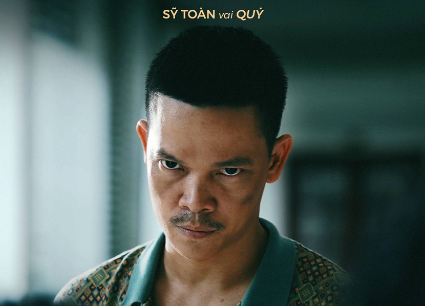 Sỹ Toàn mang ánh nhìn sắc lạnh và biểu cảm căng thẳng tạo cảm giác đe dọa, báo hiệu đây là nhân vật nhiều uẩn khúc và nguy hiểm