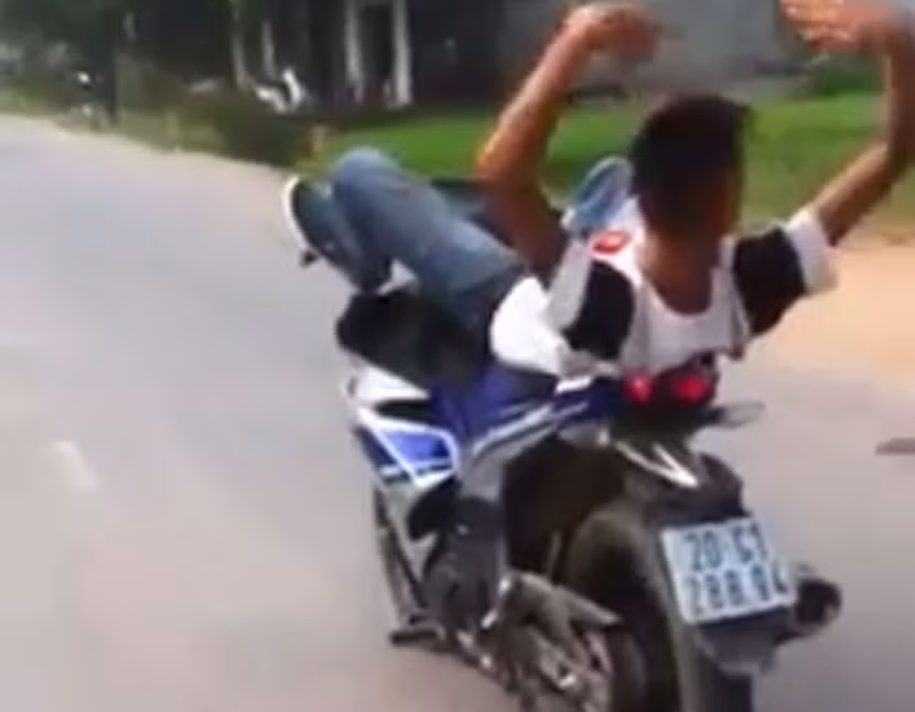 Nam thanh niên nằm ngửa lái Exciter bằng chân ảnh 1