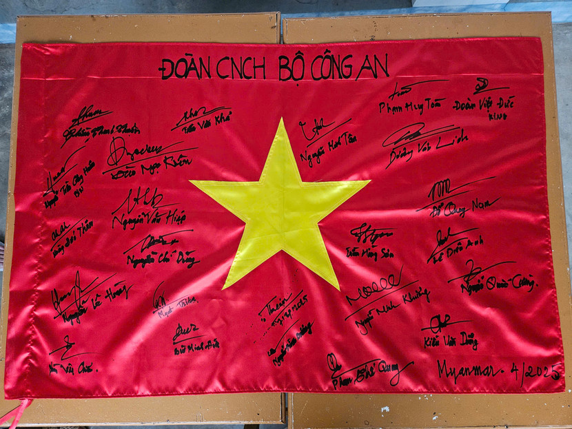 Chữ ký của các thành viên Đoàn công tác CNCH Bộ Công an trên Quốc kỳ Việt Nam