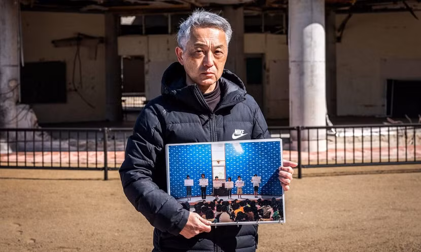 Ông Noriyuki Suzuki cùng tấm ảnh cô con gái đã mất trên nền cũ của trường Tiểu học Okawa đã bị sóng thần ập vào hôm 11-3-2011