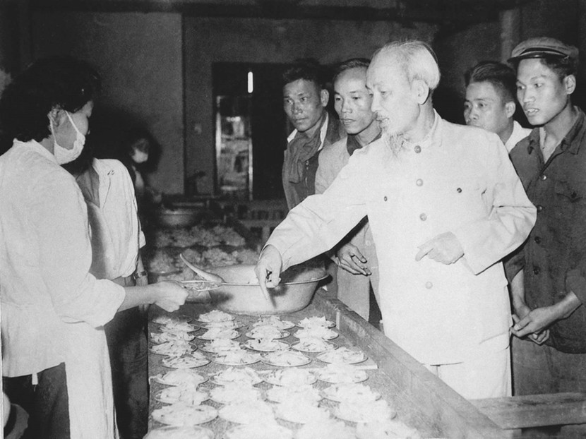 Bác Hồ thăm nhà máy cao su, xà phòng và thuốc lá Hà Nội, Người xem suất ăn bồi dưỡng giữa ca của công nhân (26-1-1961). Ảnh tư liệu