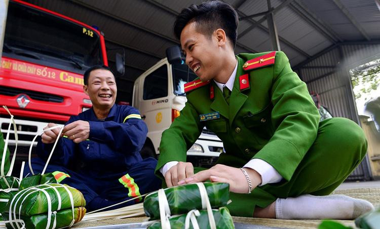 Thượng tá Đỗ Anh Quyến, Phó trưởng CAQ Bắc Từ Liêm, Hà Nội (bên trái) cùng chiến sĩ gói bánh chưng chuẩn bị đón Tết Thượng tá Đỗ Anh Quyến, Phó trưởng CAQ Bắc Từ Liêm, Hà Nội (bên trái) cùng chiến sĩ gói bánh chưng chuẩn bị đón Tết