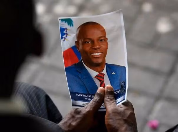 Một người dân cầm ảnh cố Tổng thống Haiti Jovenel Moïse trong lễ tưởng niệm ông ở Port-au-Prince, Haiti, ngày 20-7-2021 Một người dân cầm ảnh cố Tổng thống Haiti Jovenel Moïse trong lễ tưởng niệm ông ở Port-au-Prince, Haiti, ngày 20-7-2021