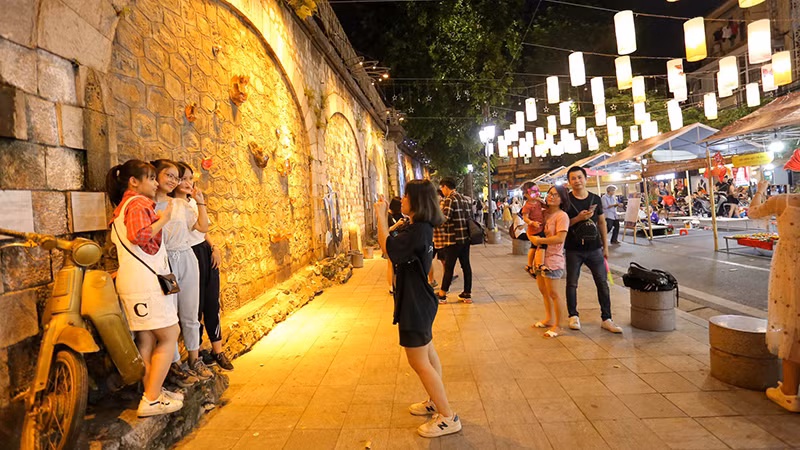 Các bạn trẻ lưu lại kỷ niệm tại phố Bích Họa Phùng Hưng