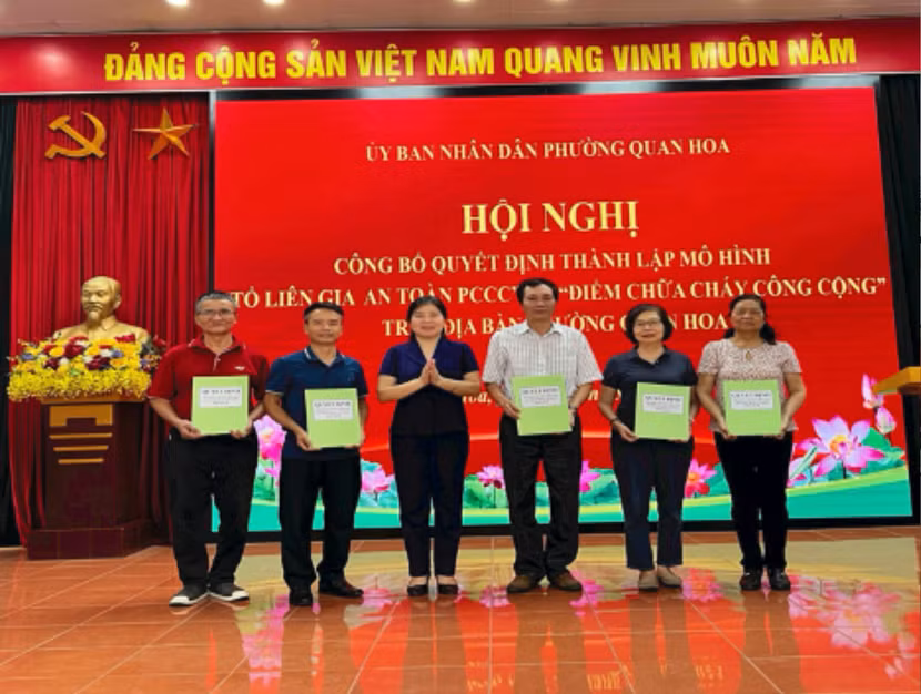 Bà Nguyễn Thị Linh Chi – Bí thư Đảng ủy phường Quan Hoa trao Quyết định thành lập Tổ liên gia an toàn PCCC cho 5 tổ dân phố