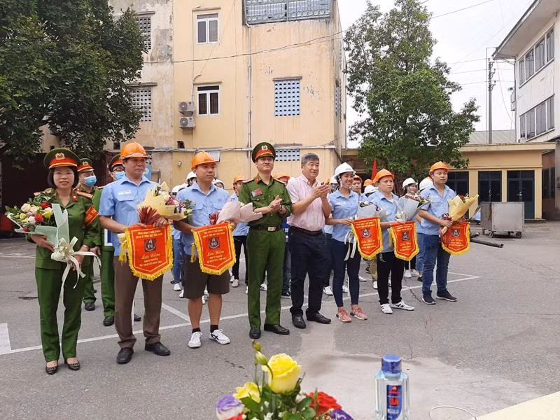 Ông Hoàng Vệ Dũng, Chủ tịch HĐQT tổng công ty may Đức Giang và Trung tá Nguyễn Đức Thiêm, Phó trưởng CAQ Long Biên trao cờ lưu niệm cho đại diện thành viên tham gia hội thao PCCC và CNCH