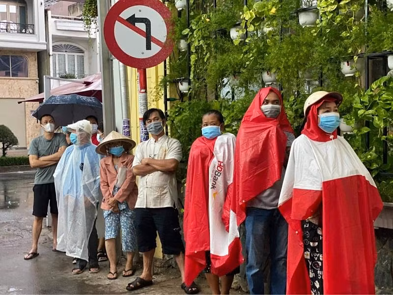 Người dân TP HCM đội mưa chờ lấy mẫu xét nghiệm