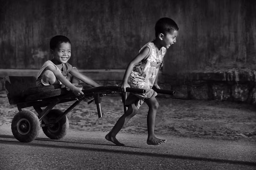 Hai em bé hồn nhiên vui chơi cùng chiếc xe thô sơ