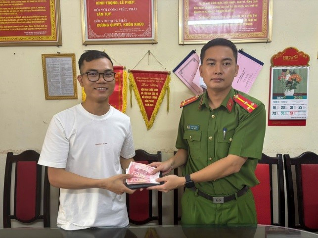 Thượng úy Tạ Thạc Nam, cán bộ Công an xã Kim Chung trao trả tài sản cho anh Bùi Xuân Tuyên