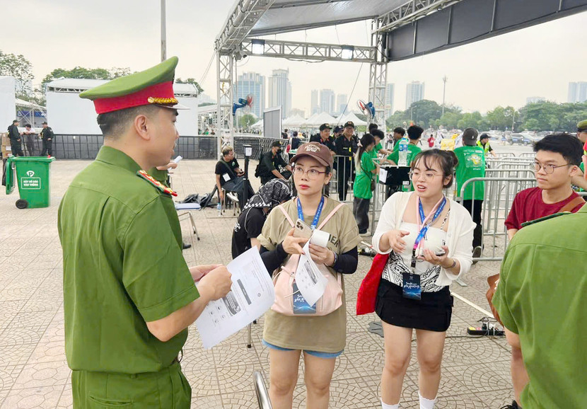 Cán bộ Phòng Cảnh sát QLHC về TTXH phát tờ rơi hướng dẫn cách thức đóng góp ý kiến dự thảo Hiến pháp sửa đổi, bổ sung trên ứng dụng VNeID cho khán giả đến xem chương trình &quot;Anh trai say Hi&quot;