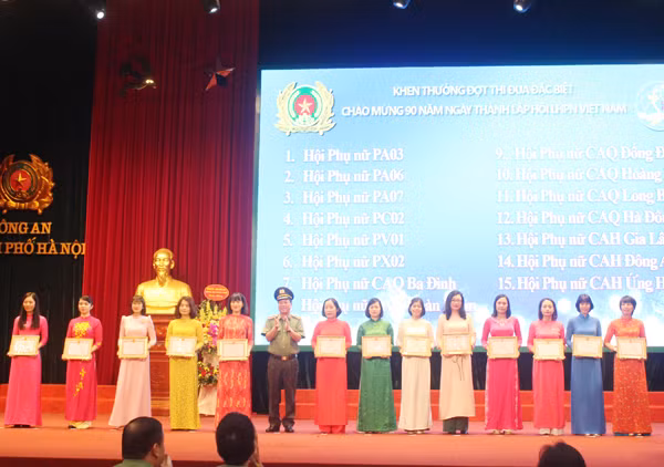 Thiếu tướng Đoàn Ngọc Hùng tặng giấy khen của Giám đốc CATP cho các tập thể có thành tích trong đợt thi đua đặc biệt chào mừng 90 năm ngày thành lập Hội LHPN Việt Nam