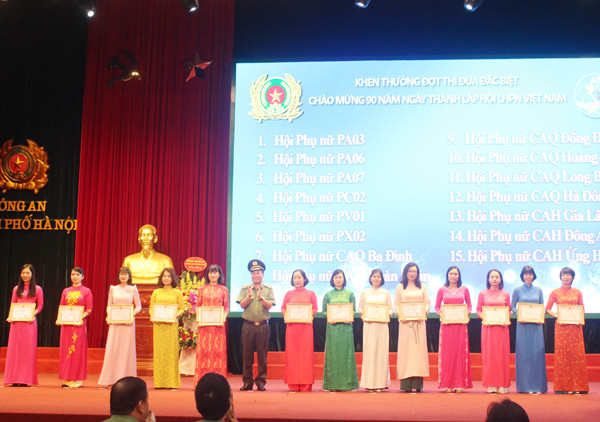 Thiếu tướng Đoàn Ngọc Hùng tặng giấy khen của Giám đốc CATP cho các tập thể có thành tích trong đợt thi đua đặc biệt chào mừng 90 năm ngày thành lập Hội LHPN Việt Nam
