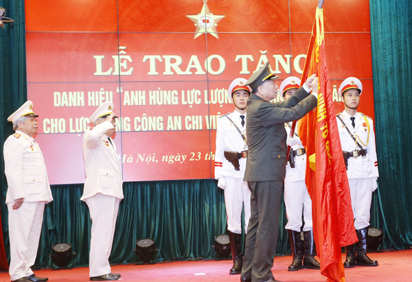 Thay mặt lãnh đạo Đảng, Nhà nước, Bộ trưởng Tô Lâm gắn danh hiệu Anh hùng LLVTND lên Cờ truyền thống của Lực lượng Công an chi viện chiến trường miền Nam
