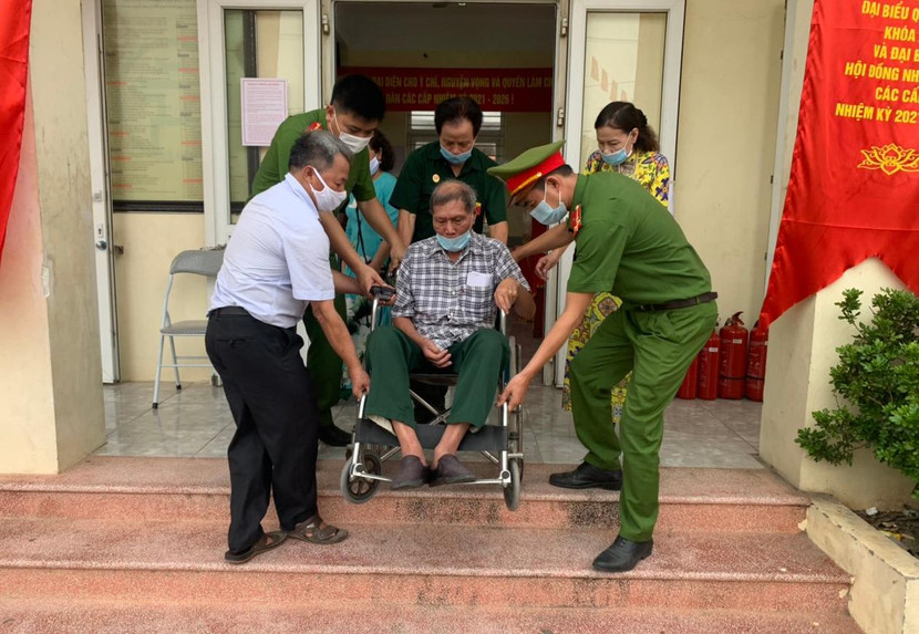 Cán bộ chiến sỹ Công an phường Liên Mạc, quận Bắc Từ Liêm giúp đỡ người khuyết tật trong quá trình tham gia bầu cử