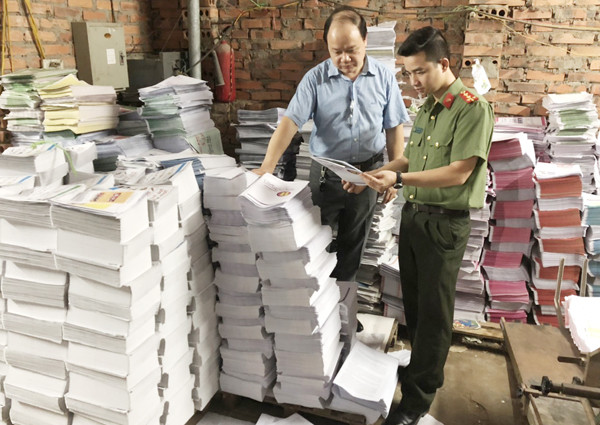 Lực lượng chức năng kiểm đếm số lượng sách thành phẩm được gia công sau in tại xưởng của anh Lưu Mạnh Trường Lực lượng chức năng kiểm đếm số lượng sách thành phẩm được gia công sau in tại xưởng của anh Lưu Mạnh Trường