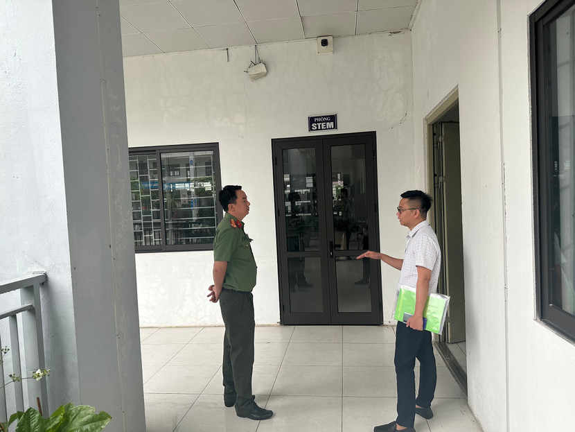 Chỉ huy Đội An ninh CAQ Bắc Từ Liêm trao đổi với cán bộ trông thi về phương án bảo vệ an toàn các điểm thi