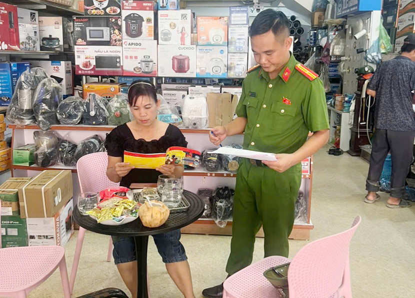 Cán bộ Công an xã phát tài liệu cẩm nang an toàn PCCC&amp;CNCH đến nhân dân