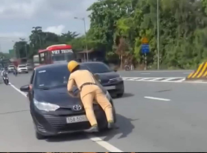 Hình ảnh chiếc xe ô tô vẫn di chuyển trong khi chiến sỹ CSGT nằm trên nắp capo