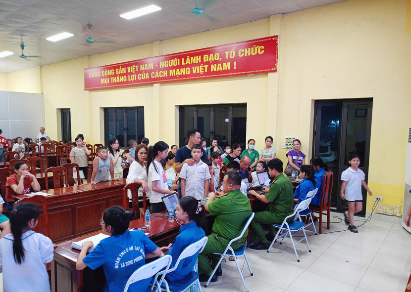 Rất đông học sinh chờ đến lượt làm hồ sơ cấp thẻ Căn cước trong tối muộn ngày 10-8 tại trụ sở Công an xã Song Phương