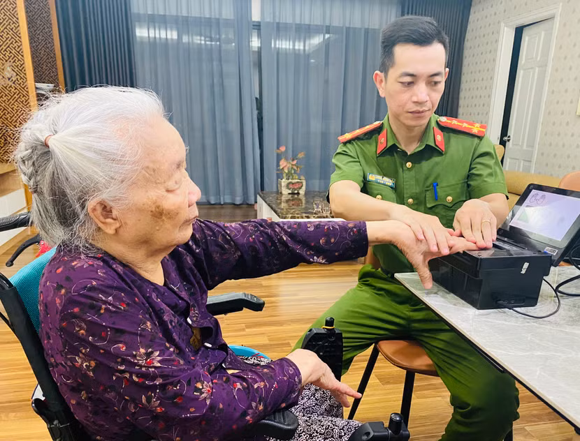 Tổ công tác lưu động CAQ Ba Đình thực hiện thủ tục lấy dấu vân tay cho cụ bà Phan Thị Thanh