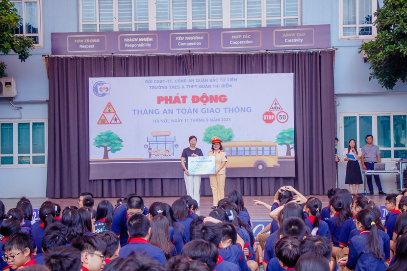 Đại diện Công an quận đã trao tặng nhà trường 50 mũ bảo hiểm và 100 cuốn sổ tay an toàn giao thông