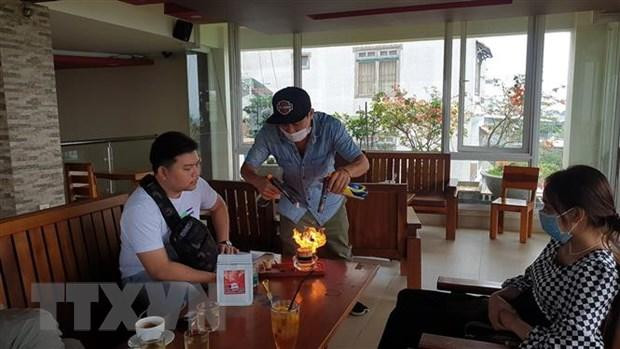 Chủ quán cà phê Photo And Bike Coffee pha chế ly cà phê cho khách thưởng thức. Ảnh: TTXVN