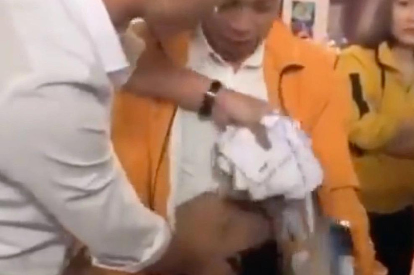 Người nhà bà Huệ lôi số phong bì bị giấu trong quần Giang. Ảnh: Cắt từ clip