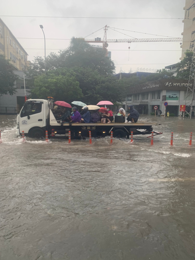 Phương tiện của lực lượng chức năng đưa người dân qua vùng ngập nút giao Mai Dịch- Phạm Hùng