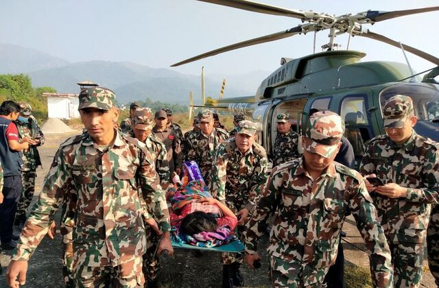 Binh sĩ Nepal khiêng người bị thương sau trận động đất Binh sĩ Nepal khiêng người bị thương sau trận động đất