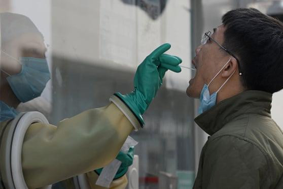 Nhân viên y tế lấy mẫu xét nghiệm Covid-19 cho người đàn ông ở Bắc Kinh