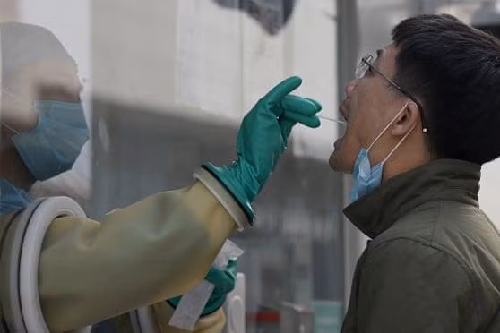 Nhân viên y tế lấy mẫu xét nghiệm Covid-19 cho người đàn ông ở Bắc Kinh