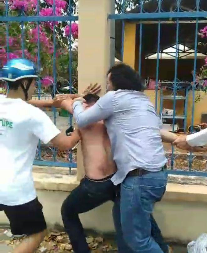 Thầy Vinh (bìa phải) cùng người dân khống chế nghi can cướp. Ảnh cắt từ clip