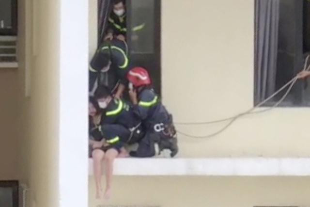 Cảnh sát tiếp cận từ cửa sổ giải cứu cô gái có ý định nhảy lầu tự tử. Ảnh: Dân Trí