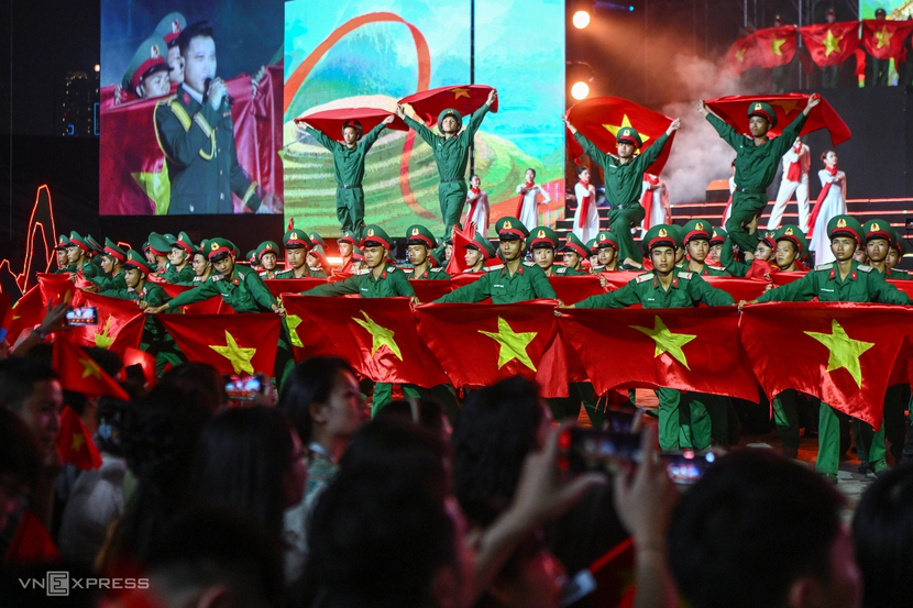 Hàng trăm lá cờ đỏ sao vàng được mang lên sân khấu trong bài “Đường chúng ta đi” (nhạc sĩ Huy Du) trong chương trình “Hẹn ước Bắc - Nam” kỷ niệm 50 năm thống nhất đất nước ở SVĐ Quốc gia Mỹ Đình