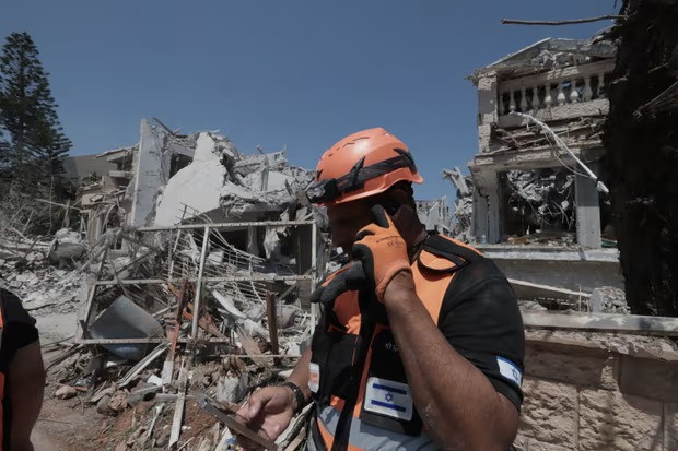 Nhân viên cứu hộ tại Rishon LeZion - vùng ngoại ô của Tel Aviv, nơi bị một tên lửa đạn đạo của Iran bắn trúng vào ngày 14-6