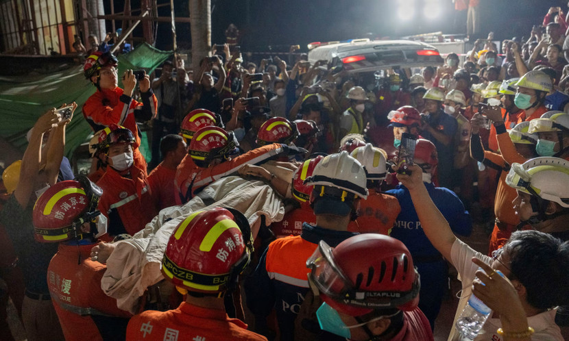 Lực lượng cứu hộ đưa 1 phụ nữ ra khỏi đống đổ nát của Khách sạn Great Wall ở Mandalay