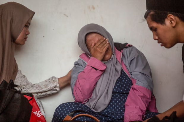 Một phụ nữ bật khóc khi chờ đợi thông tin về hoạt động cứu hộ