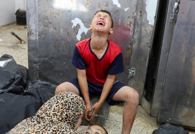 Thiếu niên Palestine khóc thương em gái thiệt mạng trong vụ Israel không kích đám đông xếp hàng trước trạm xá ngày 10-7