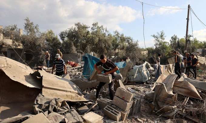 Người dân Palestine tại khu vực trúng đòn tập kích của Israel ở Nuseirat, Dải Gaza, ngày 13-7