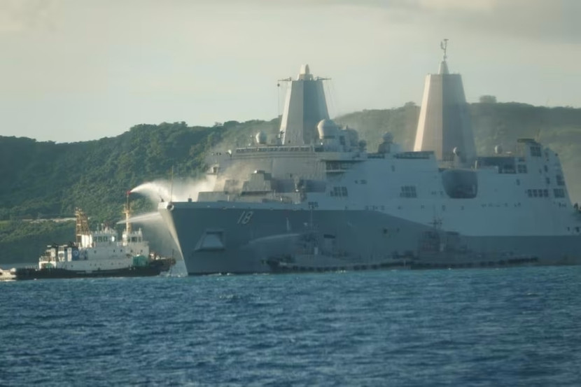 Các tàu kéo đang phun nước vào mũi tàu USS New Orleans để dập tắt đám cháy