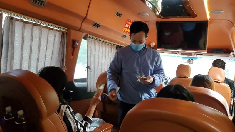 Nhân viên nhà xe limousine thu tiền vé của hành khách trên xe