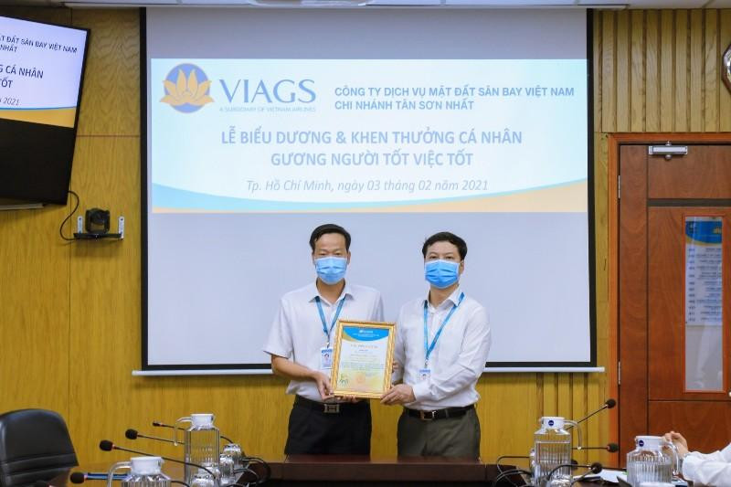 Anh Phạm Hữu Tuân (bên trái) nhận thư khen của ban lãnh đạo VIAGS tại Tân Sơn Nhất vì hành động ý nghĩa.