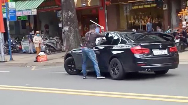 Nam thanh niên cầm gậy đập ô tô của người phụ nữ. Ảnh cắt từ clip Nam thanh niên cầm gậy đập ô tô của người phụ nữ. Ảnh cắt từ clip