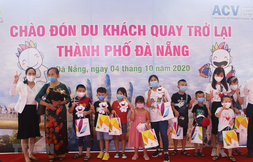 Tặng quà cho đoàn khách đầu tiên trở lại du lịch thành phố Đà Nẵng sau dịch Covid-19. Ảnh: TTXVN