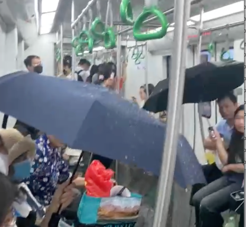 Cảnh người dân phải lấy ô che trên chuyến tàu metro Cát Linh- Hà Đông vào chiều tối nay 19/5