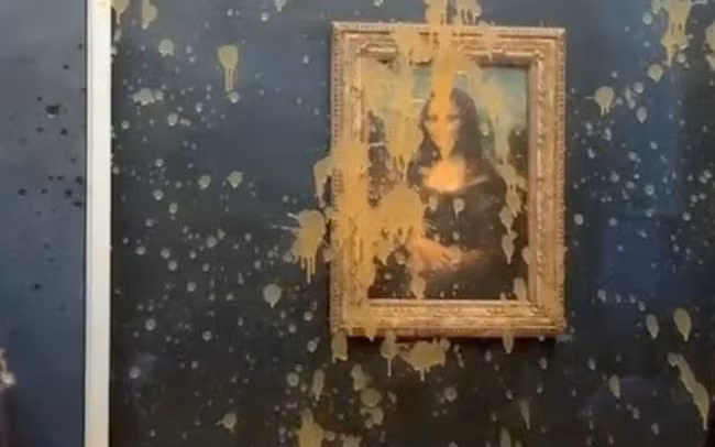 Hai người biểu tình đã hắt nước súp màu cam lên tấm kính bảo vệ bức tranh Mona Lisa