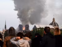 Người dân Paris quỳ gối cầu nguyện trước cảnh nhà thờ Đức Bà bị lửa thiêu rụi